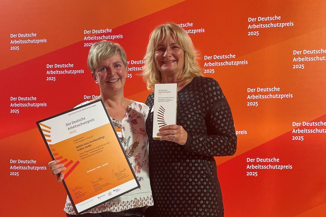 Pflegeunternehmerin Birgit Kröber von der Mobilen Haus-Krankenpflege Kröber GmbH (rechts) und bgm-Koordinatorin Claudia Hesse nehmen den Deutschen Arbeitsschutzpreis 2025 Kategorie „Kulturell“ entgegen