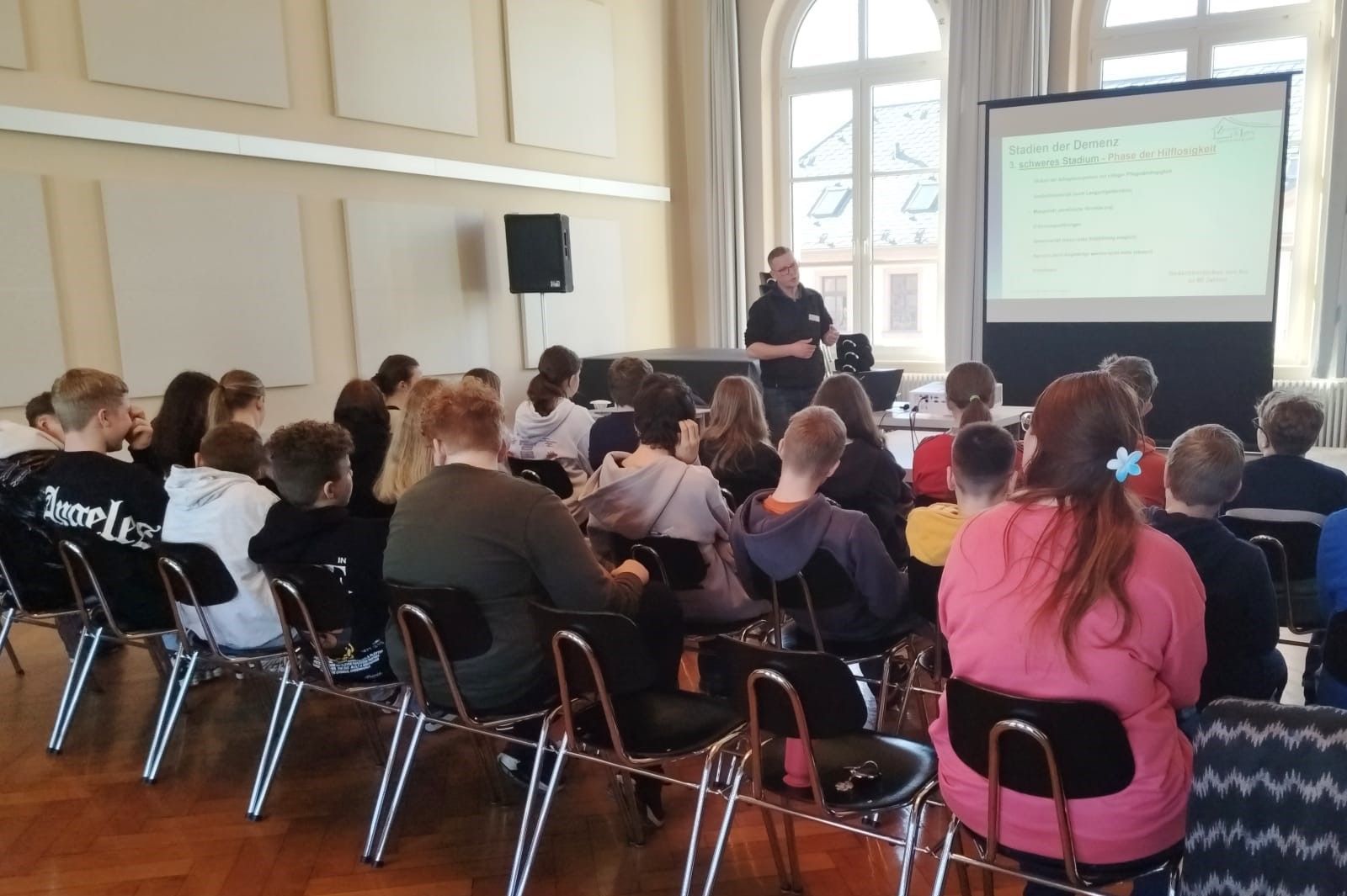 Lars Zeißig (leitender Ergotherapeut, Z & L Unternehmensgruppe) vor einer Schulklasse.